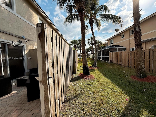 view of yard with a patio area and glass enclosure