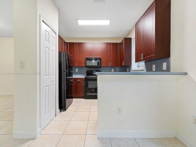 kitchen with light tile patterned floors, kitchen peninsula, and black appliances