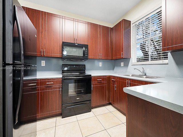 kitchen featuring sink, light tile patterned floors, and black appliances