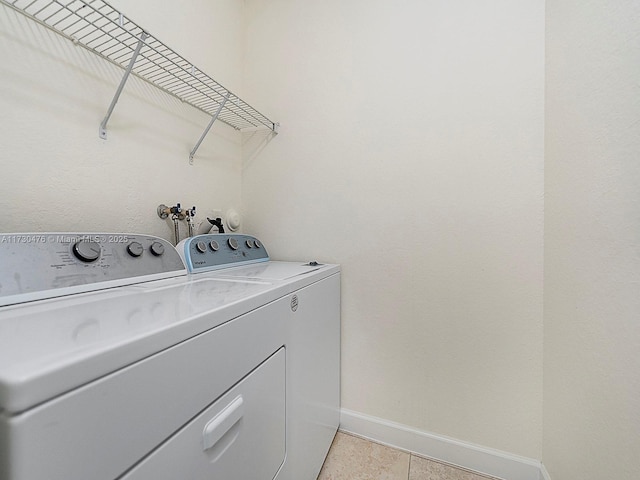 laundry room with light tile patterned flooring and washer and dryer