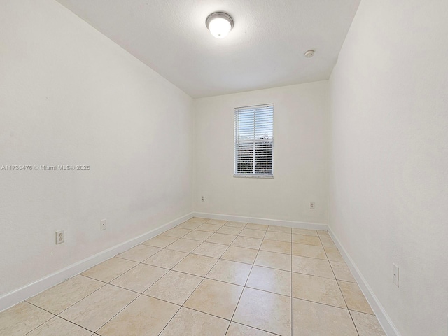 tiled empty room with a textured ceiling