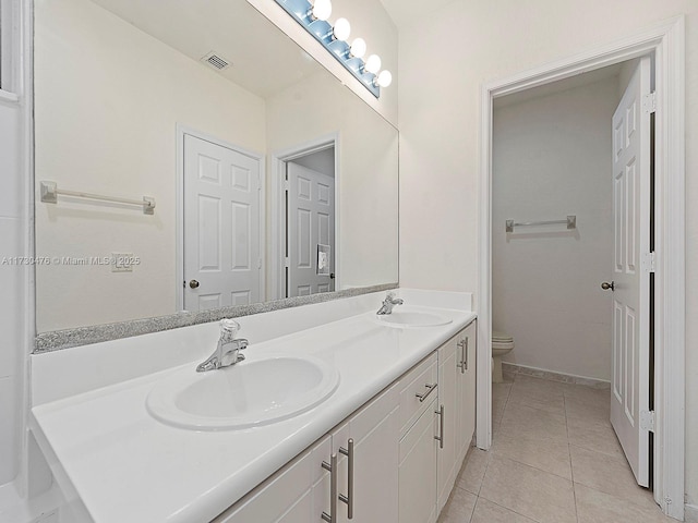 bathroom with tile patterned flooring, vanity, and toilet