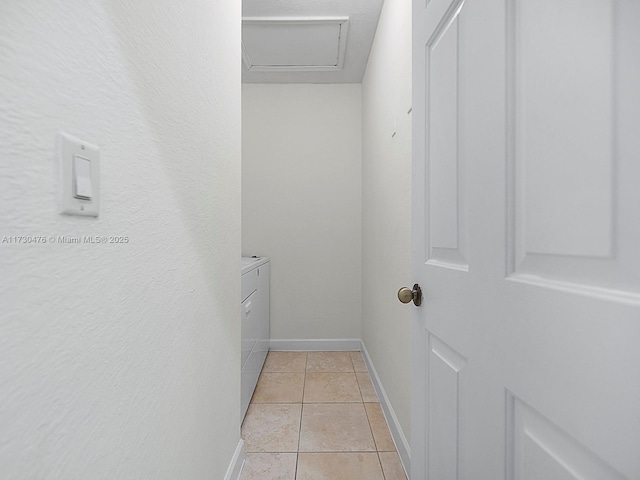 spacious closet featuring washer and dryer and light tile patterned flooring