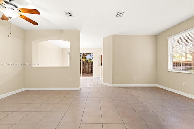 tiled empty room featuring ceiling fan