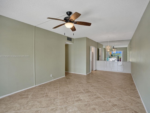 unfurnished room with light tile patterned floors, ceiling fan with notable chandelier, and a textured ceiling