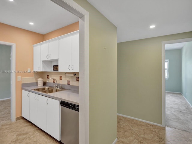 kitchen featuring white cabinetry, stainless steel dishwasher, sink, and light tile patterned floors