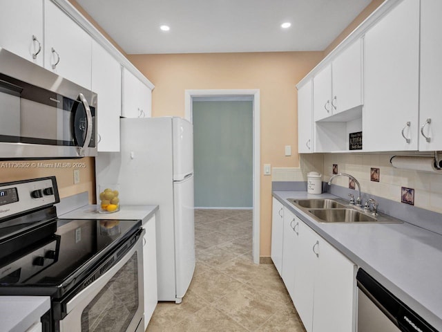 kitchen with sink, white cabinets, backsplash, light tile patterned floors, and stainless steel appliances