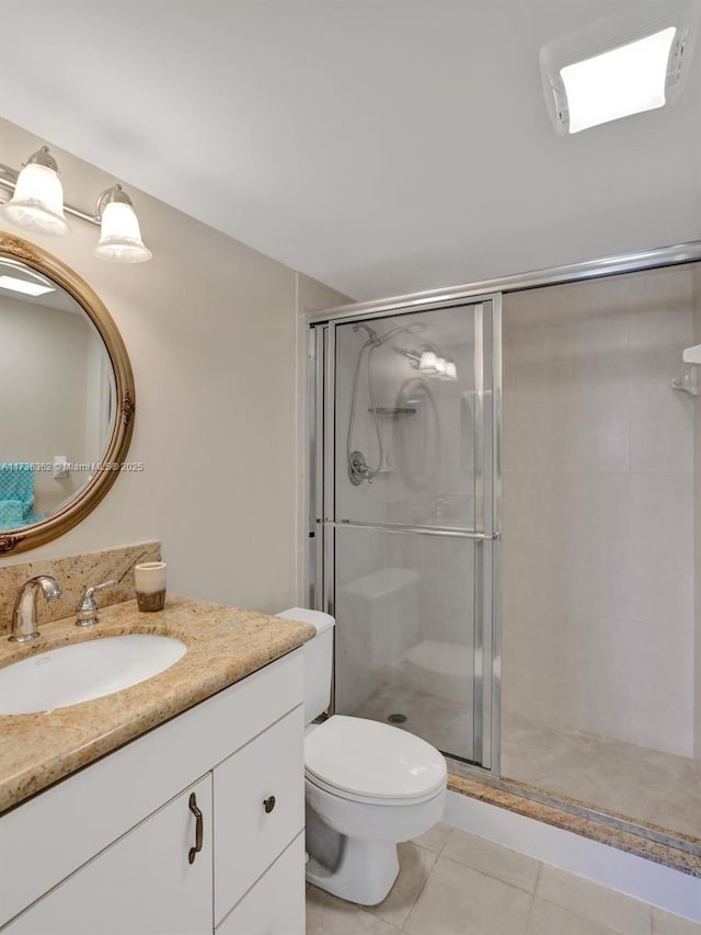 bathroom featuring tile patterned flooring, vanity, toilet, and walk in shower