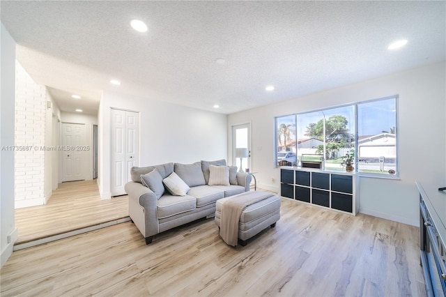 living room featuring light hardwood / wood-style floors and a textured ceiling