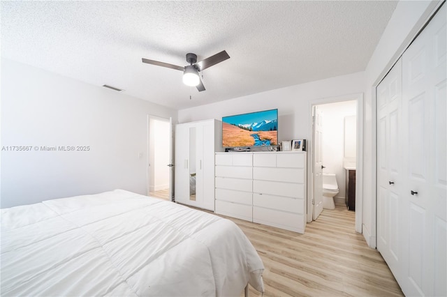 bedroom featuring connected bathroom, light hardwood / wood-style flooring, ceiling fan, a textured ceiling, and a closet