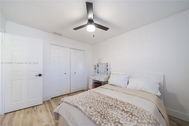 bedroom with a textured ceiling, light hardwood / wood-style floors, and a closet