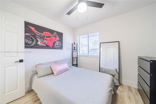 bedroom with ceiling fan, a textured ceiling, and light wood-type flooring