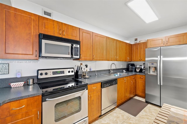 kitchen with stainless steel appliances, sink, and light tile patterned floors