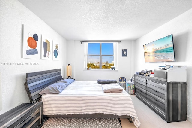 bedroom with light colored carpet and a textured ceiling