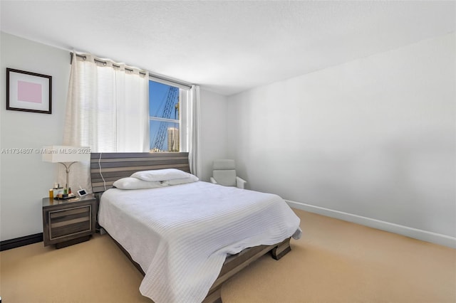 bedroom featuring light colored carpet and a textured ceiling