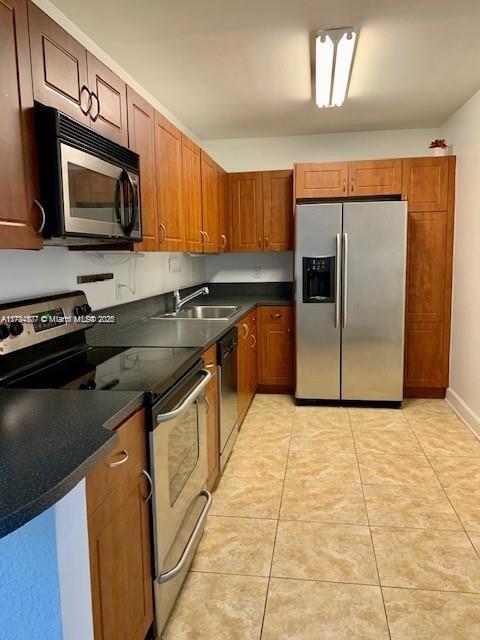 kitchen featuring sink, light tile patterned flooring, and appliances with stainless steel finishes