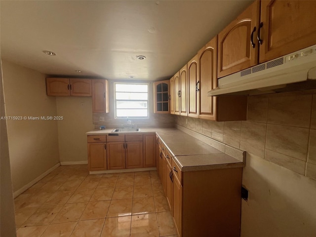 kitchen with light brown cabinetry, sink, decorative backsplash, and light tile patterned floors