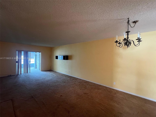 unfurnished room featuring carpet floors, a notable chandelier, and a textured ceiling