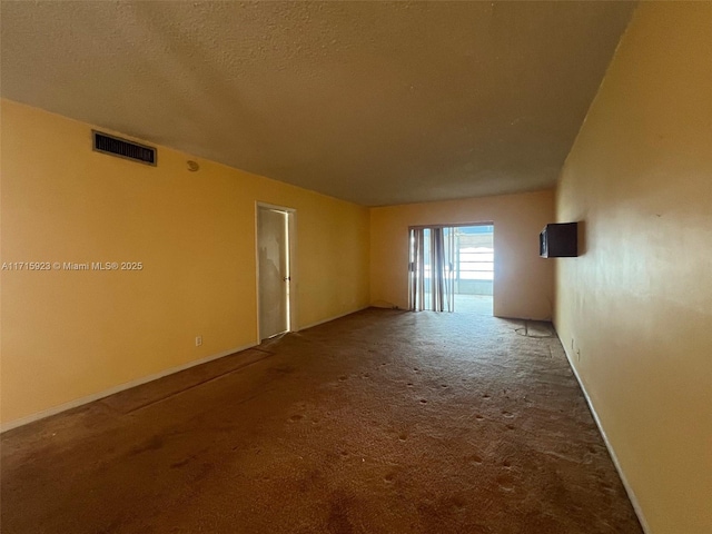 carpeted spare room with a textured ceiling