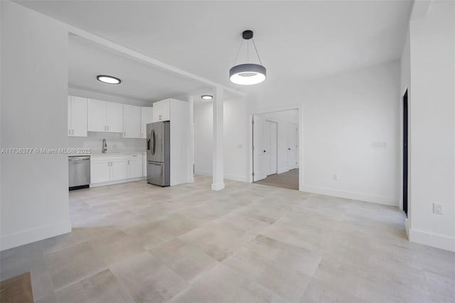 kitchen with white cabinetry, appliances with stainless steel finishes, sink, and decorative light fixtures