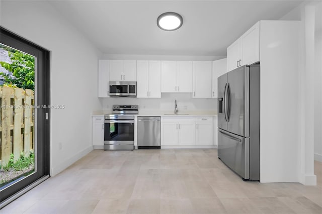 kitchen featuring sink, stainless steel appliances, and white cabinets