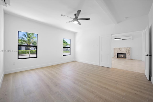 unfurnished living room featuring light hardwood / wood-style flooring, a tile fireplace, and ceiling fan