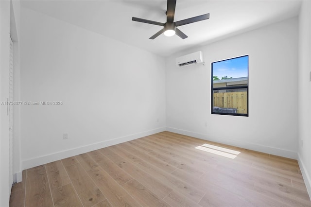 unfurnished room featuring ceiling fan, a wall mounted air conditioner, and light hardwood / wood-style floors