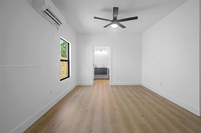 empty room featuring ceiling fan, a wall unit AC, and light hardwood / wood-style flooring