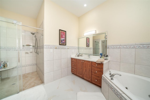 bathroom featuring independent shower and bath, vanity, and tile walls