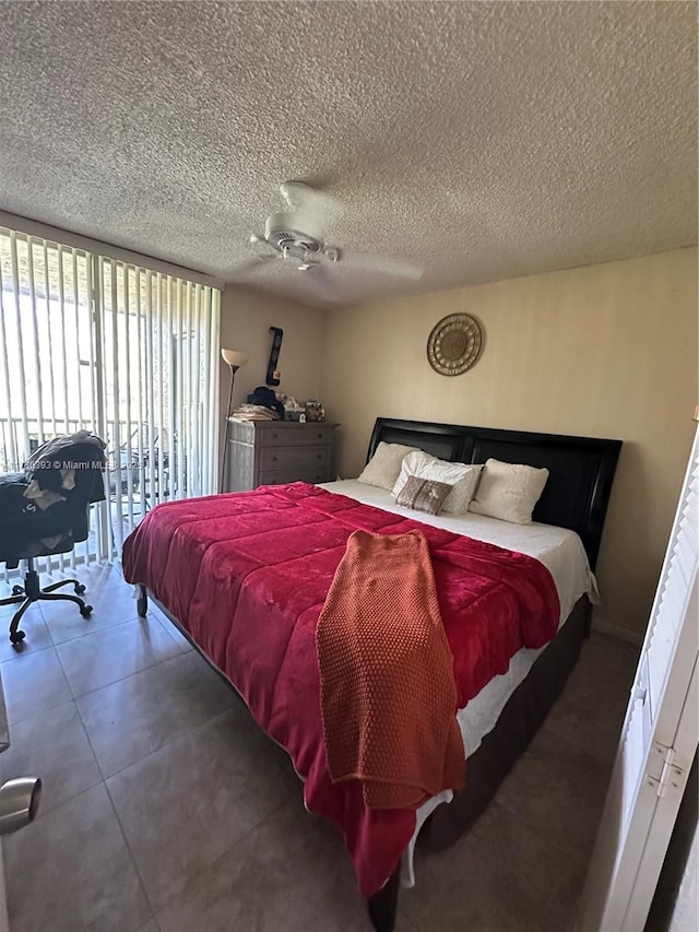 bedroom featuring ceiling fan, access to exterior, a textured ceiling, and a wall of windows