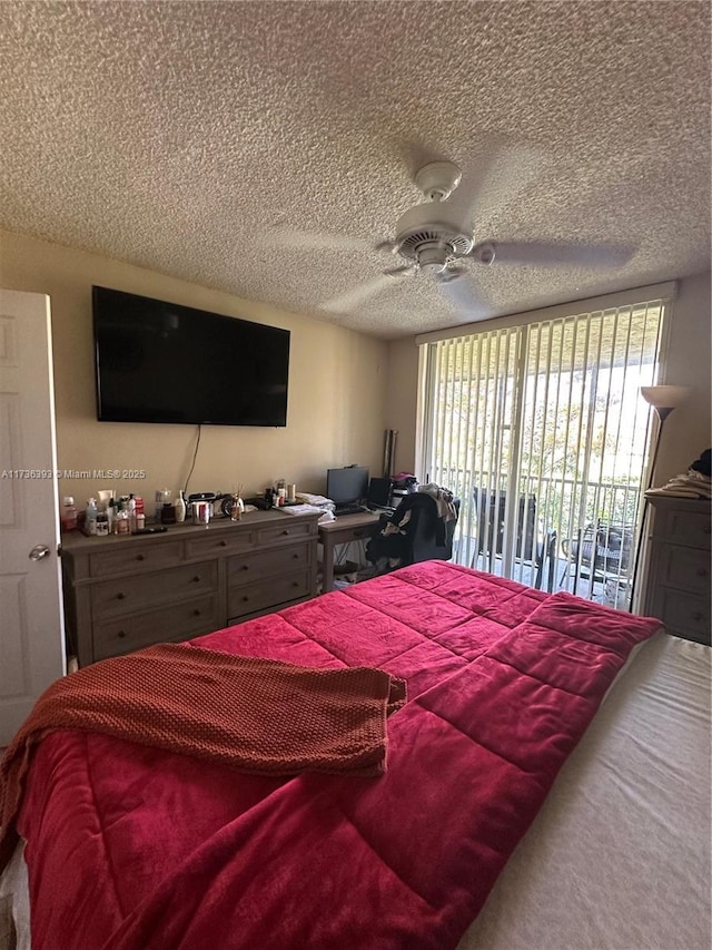 bedroom with ceiling fan, access to exterior, and a textured ceiling