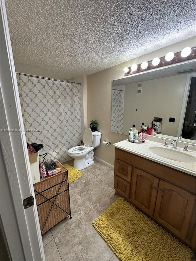 bathroom with vanity, tile patterned flooring, toilet, and a textured ceiling