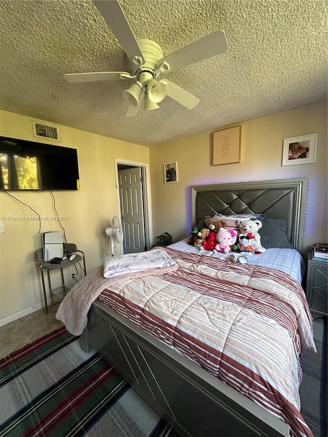 tiled bedroom with a textured ceiling and ceiling fan