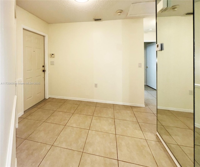 tiled spare room with a textured ceiling