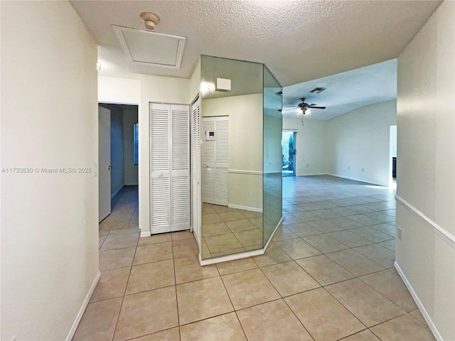 hall with light tile patterned floors and a textured ceiling