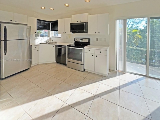 kitchen with white cabinetry, appliances with stainless steel finishes, sink, and light tile patterned floors