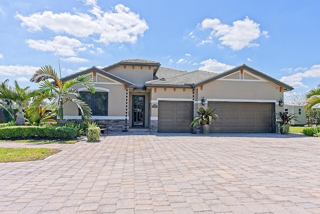 view of front of home featuring a garage, decorative driveway, and stucco siding