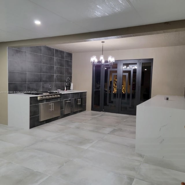 kitchen featuring french doors, stainless steel gas cooktop, sink, hanging light fixtures, and beamed ceiling