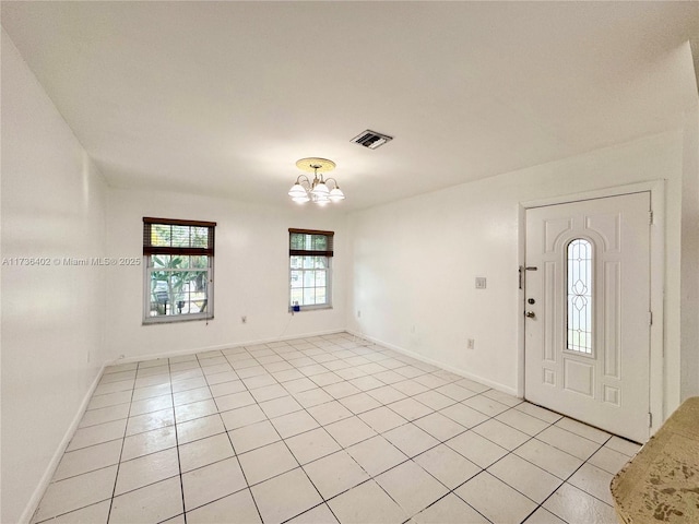 entrance foyer featuring light tile patterned floors and a chandelier