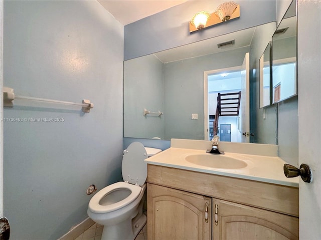 bathroom with vanity, toilet, and tile patterned flooring