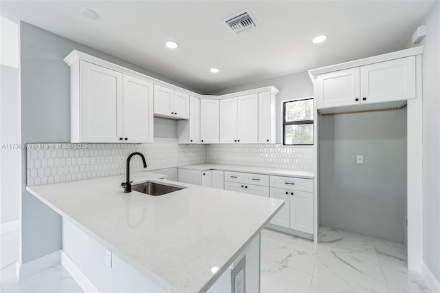 kitchen featuring sink, white cabinets, and kitchen peninsula