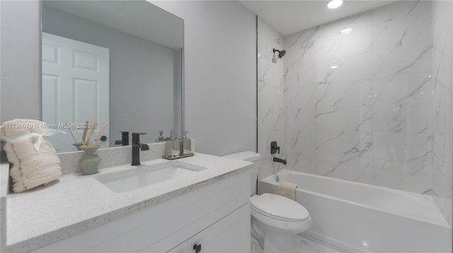 full bathroom with vanity, tiled shower / bath combo, and toilet