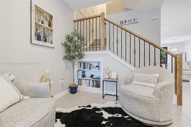 living area with a chandelier and light tile patterned flooring