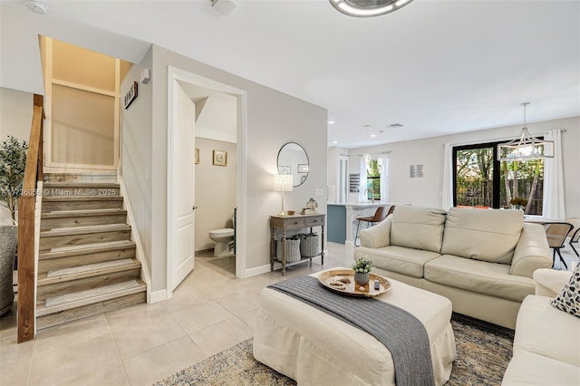 tiled living room featuring a notable chandelier