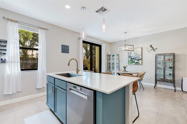 kitchen with hanging light fixtures, dishwasher, sink, and a center island with sink