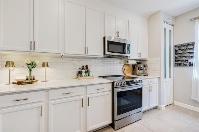 kitchen featuring white cabinetry, stainless steel appliances, tasteful backsplash, and light tile patterned floors