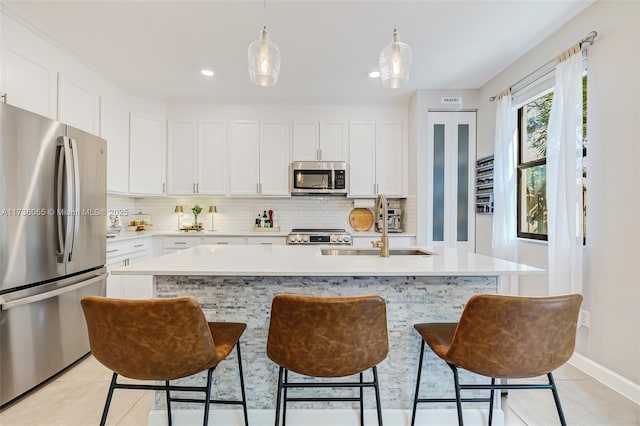 kitchen featuring sink, an island with sink, white cabinets, and appliances with stainless steel finishes