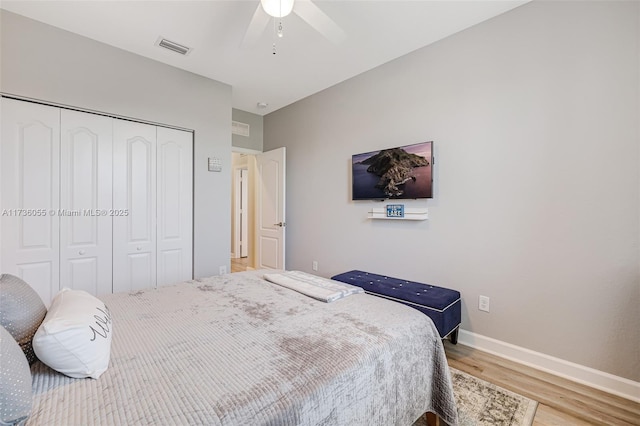 bedroom with ceiling fan, light wood-type flooring, and a closet