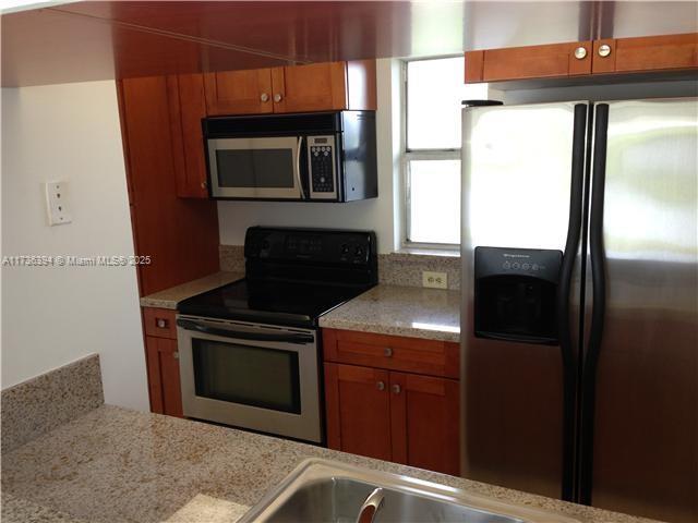 kitchen with light stone counters and stainless steel appliances