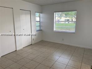 unfurnished bedroom featuring two closets and light tile patterned floors